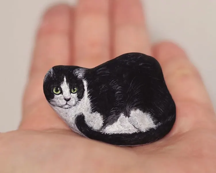 An image of a cat painted on a stone by Akie Nakata