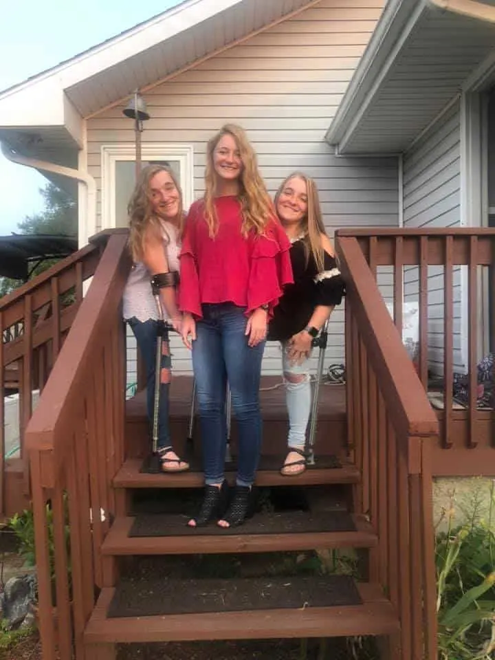 The Garrison triplets at home standing on their backyard porch.