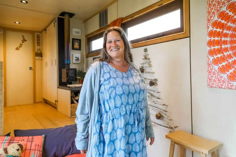 A woman standing inside her off-grid tiny house truck