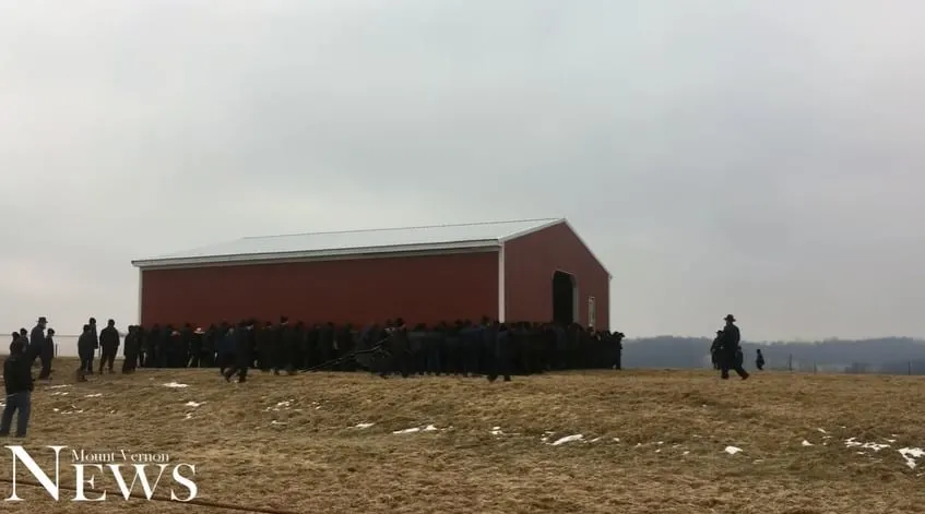 Amish men moving a barn