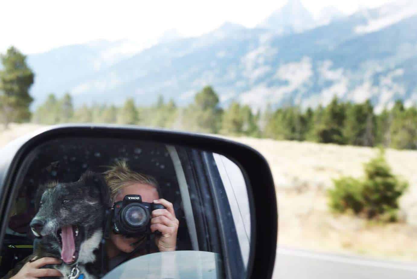 Emily Trost taking a photo of herself with Montana on their car's side window