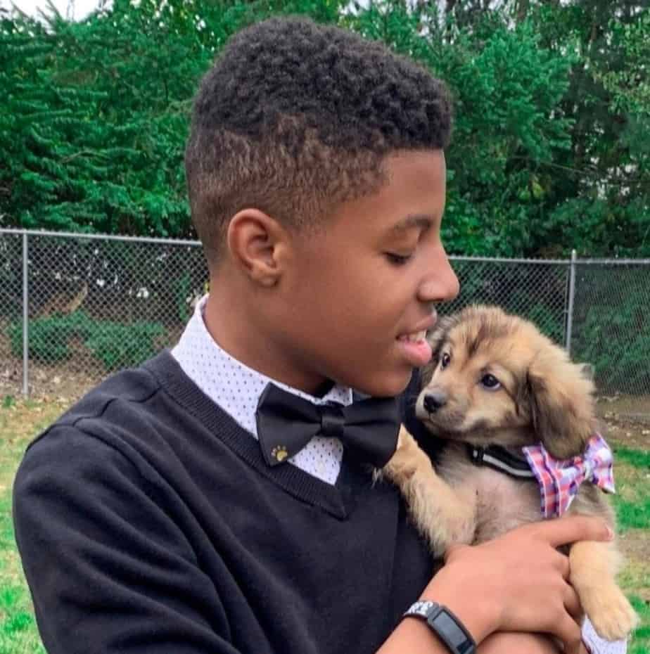 Darius Brown holding a puppy wearing a bow tie