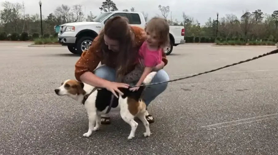 Brooke Lake and her daughter petting Lilly the beagle