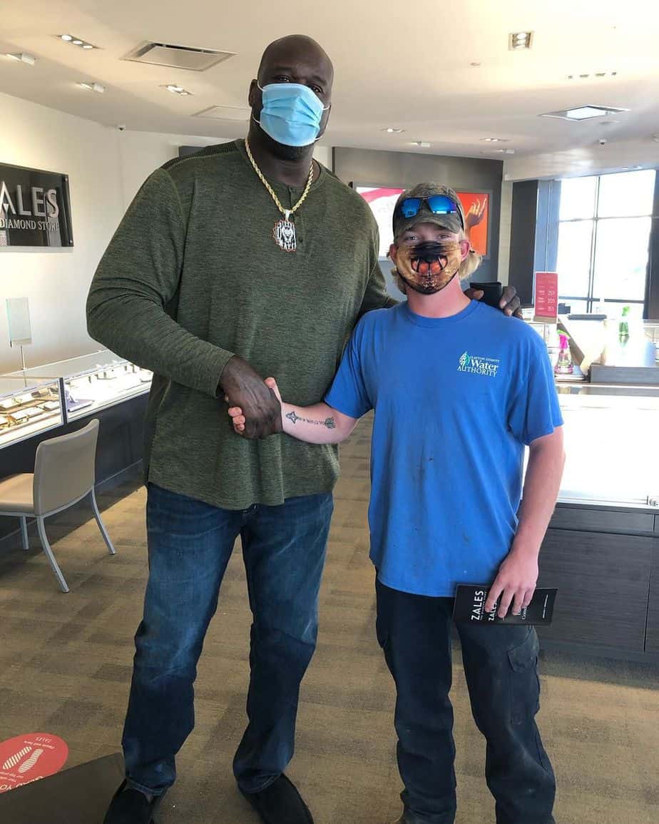Shaquille O'Neal posing for a photo beside a man inside a Zales store