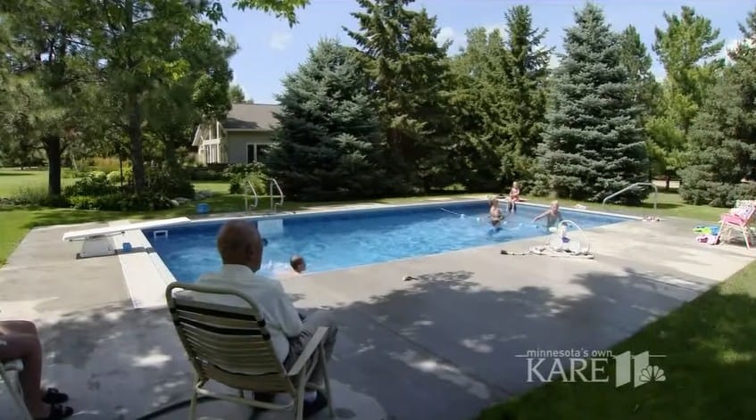 Keith Davison sitting on his lawn chair while watching kids swim in his backyard pool