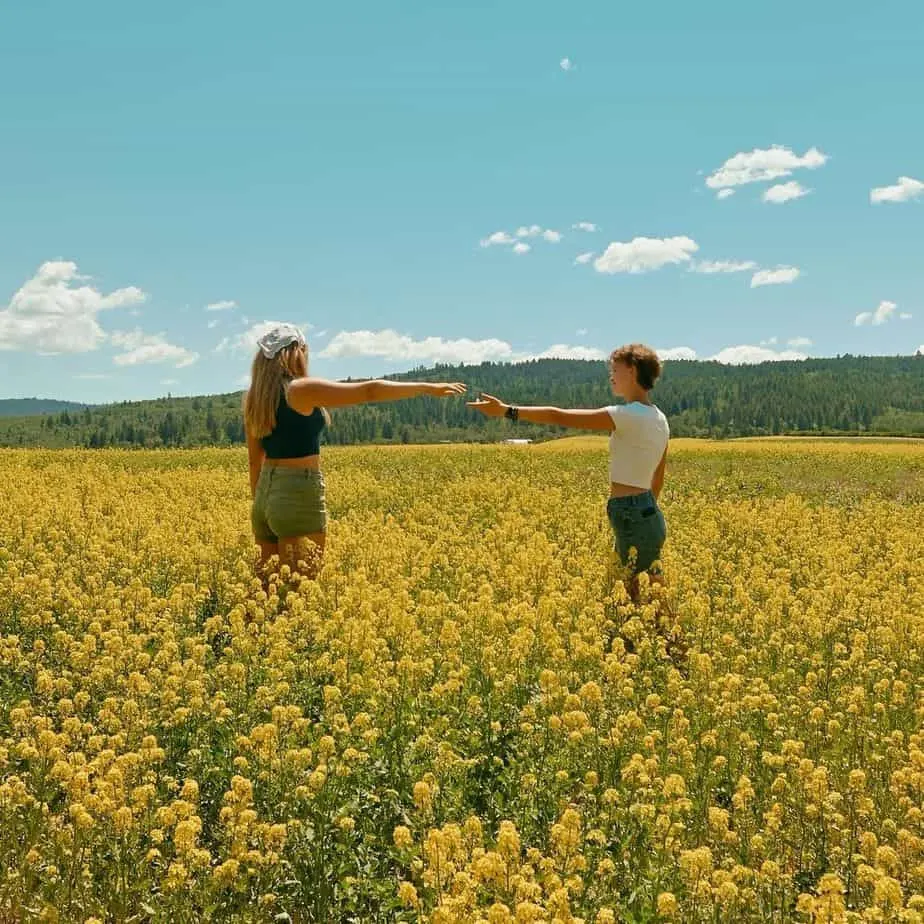 Two women holding hands in the middle of a field