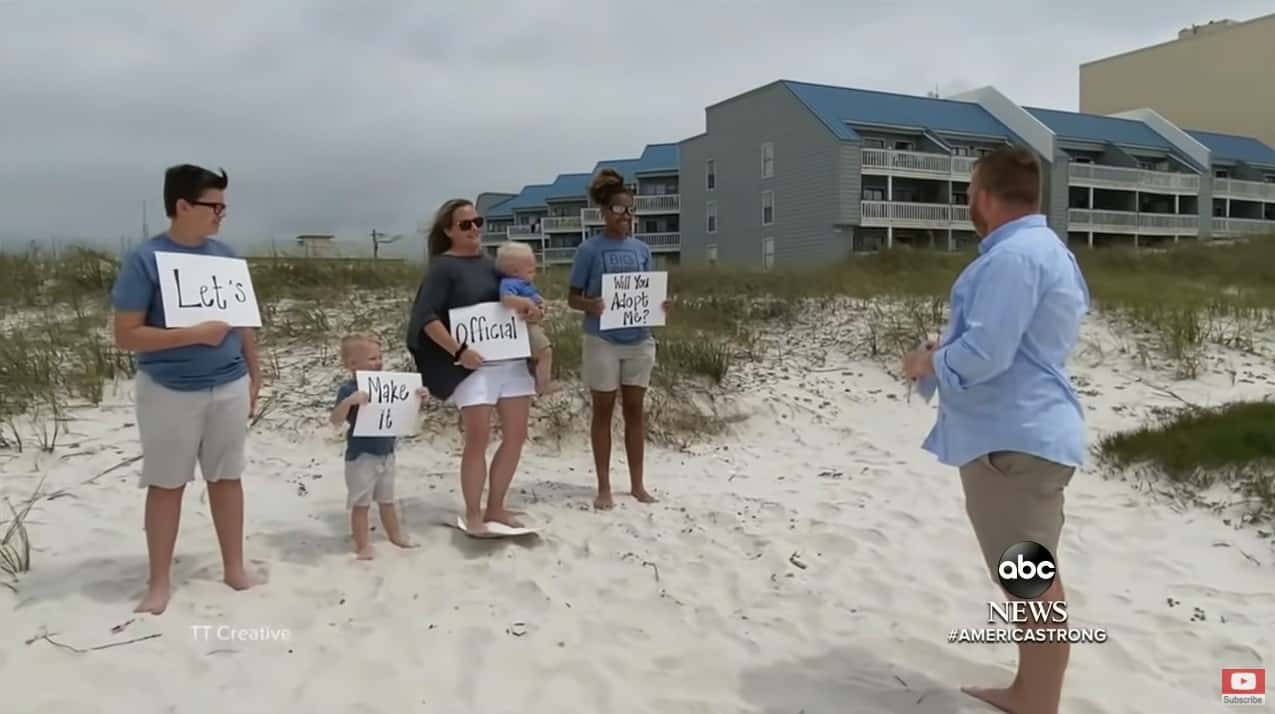 The Donaldson family and Alecia holding up signs as Daniel Donaldson reads them