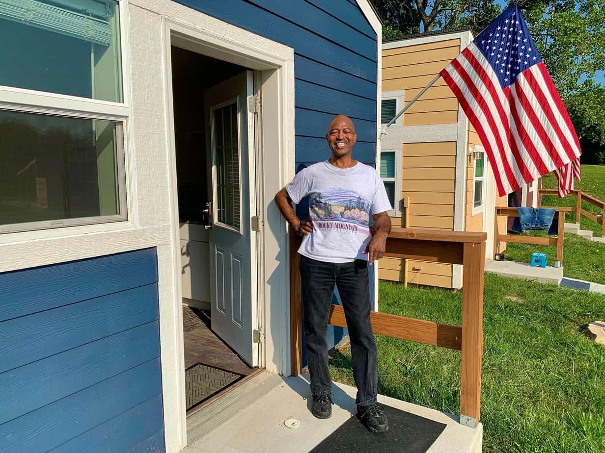 A veteran on the porch of his home in the VCP Village built by a non-profit
