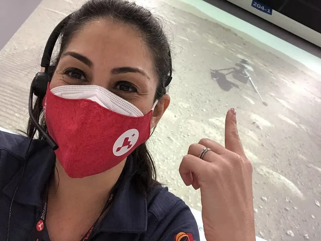 Diana Trujillo wearing a red face mask and headphones at NASA