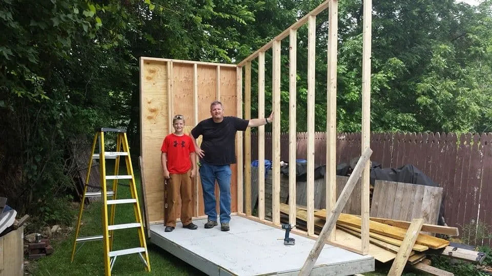 Luke Thill and his dad, Greg Thill, standing inside the tiny home they're building