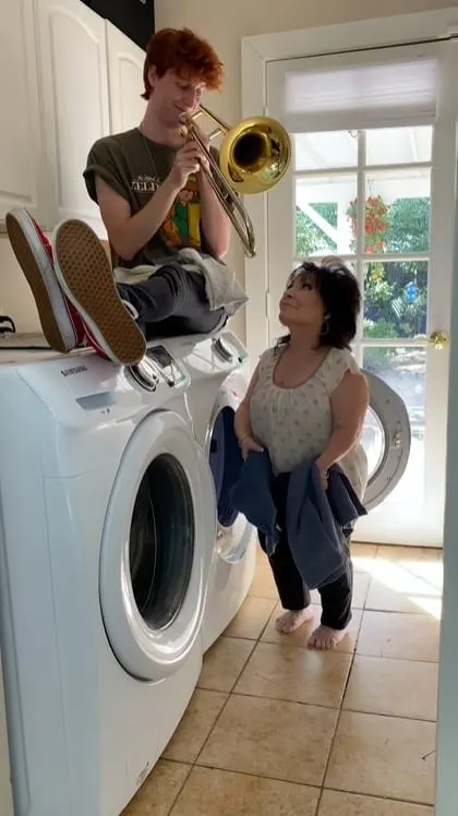 Peet Montzingo sound-effecting his mom with a trombone while she's doing the laundry
