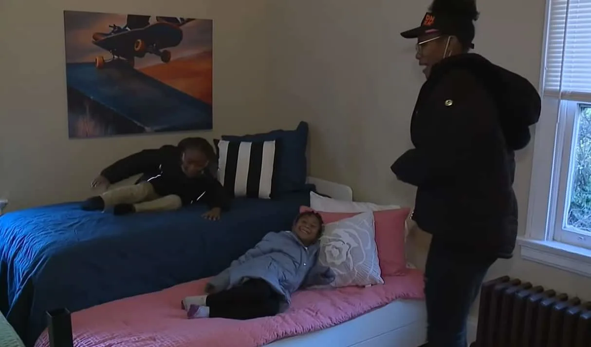Ebony Johnson's two kids trying out their new bed as their mother looked on 
