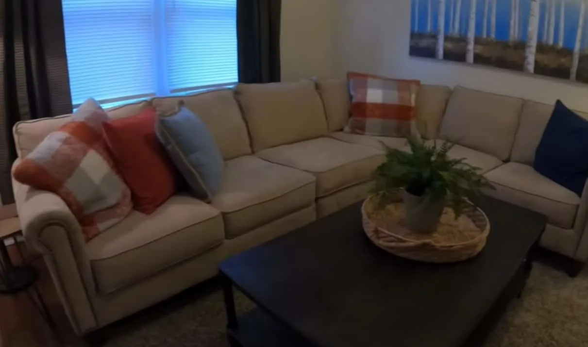 A couch with throw pillows in the Johnson family's new home