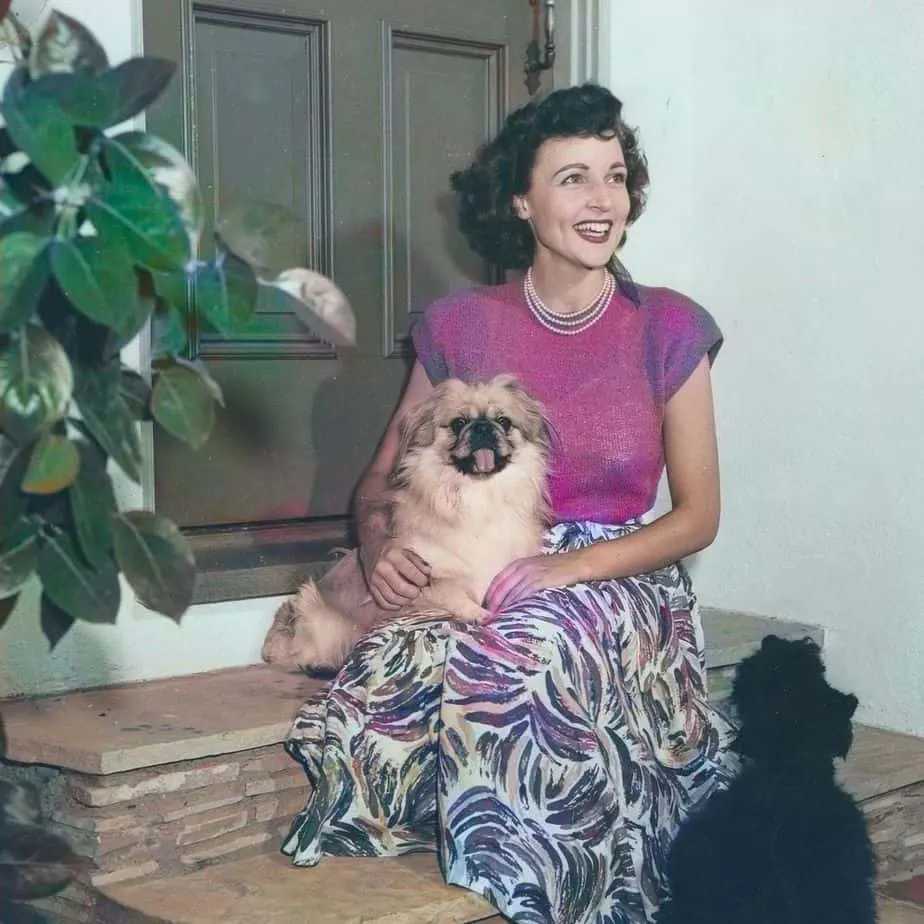 A young Betty White with two dogs
