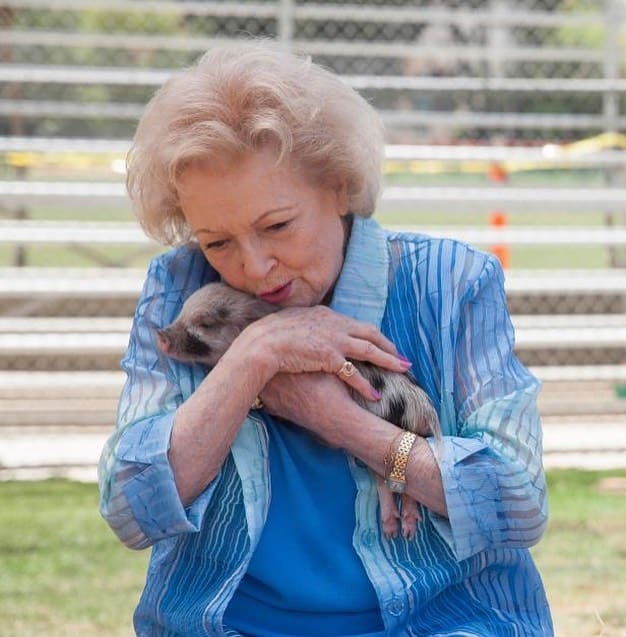 Betty White hugging a piglet