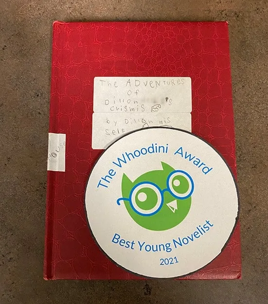 "The Adventures of Dillon Helbig's Crismis" with "The Whoodini Award for Best Young Novelist" badge