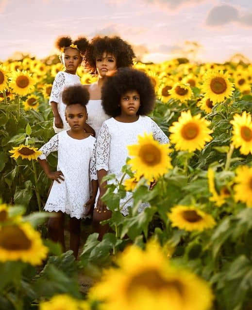 Diamond Jackson and her three daughters standing on a sunflower field