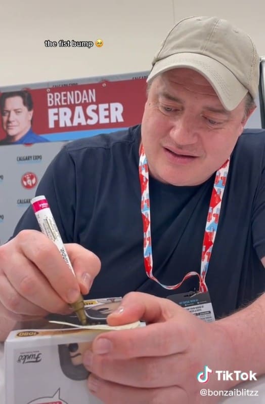 Brendan Fraser signing the box of a Funko doll during the Calgary Expo