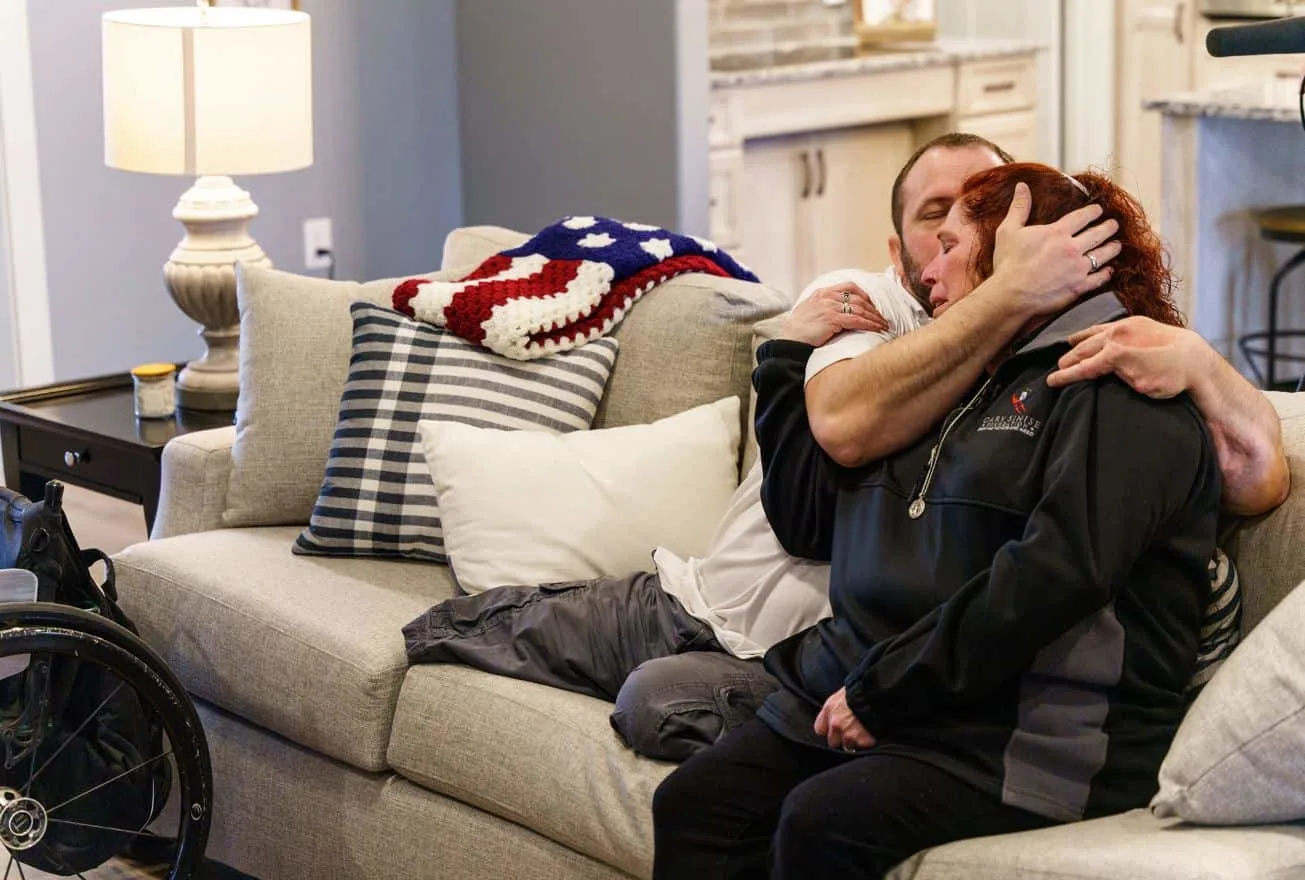 U.S. Army SGT Christopher Kurtz and his wife Heather sitting on the couch in their new smart home