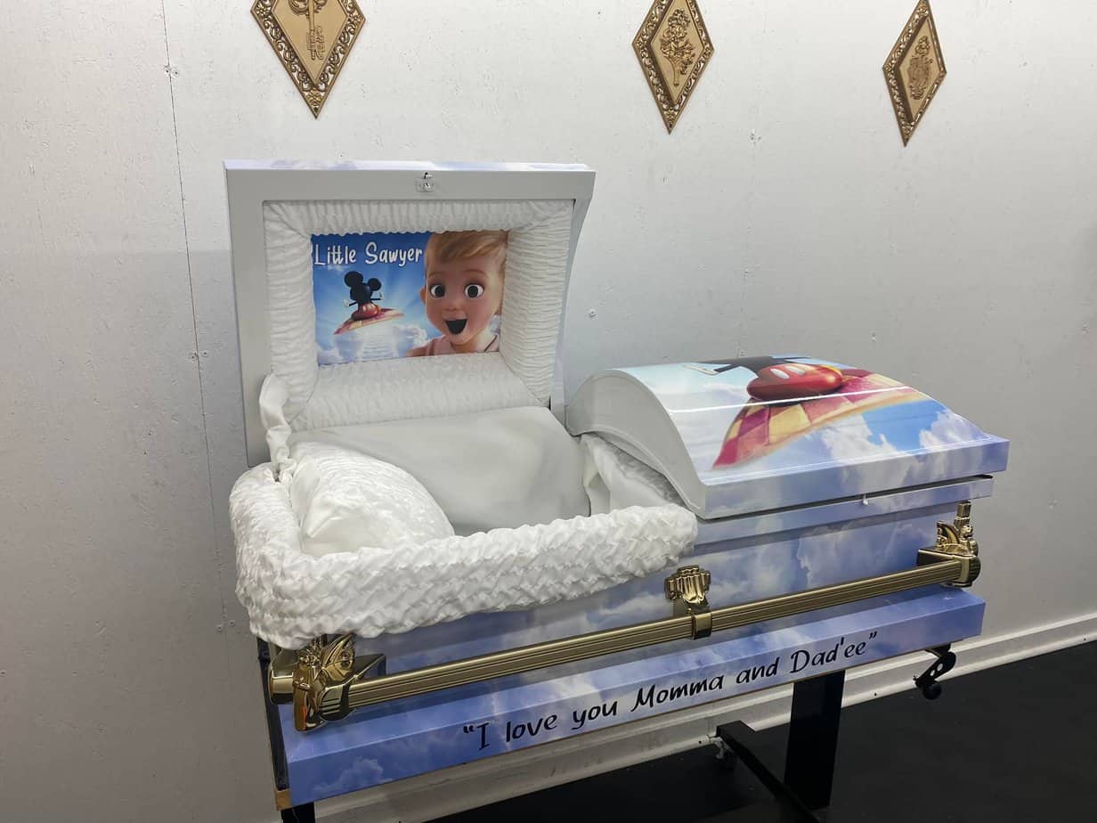 An open casket with an image of Mickey Mouse on a floating carpet flying towards a boy