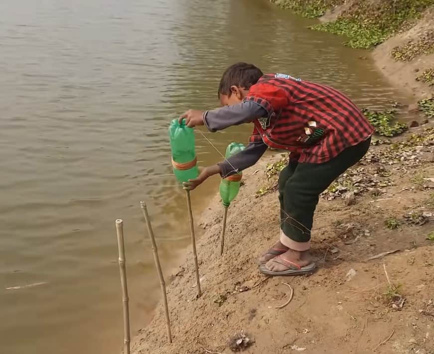 A young boy arranging his fishing set up 