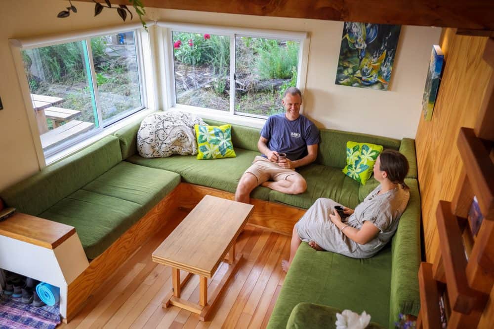 Claire and Tim sitting on the sofa of their tiny home