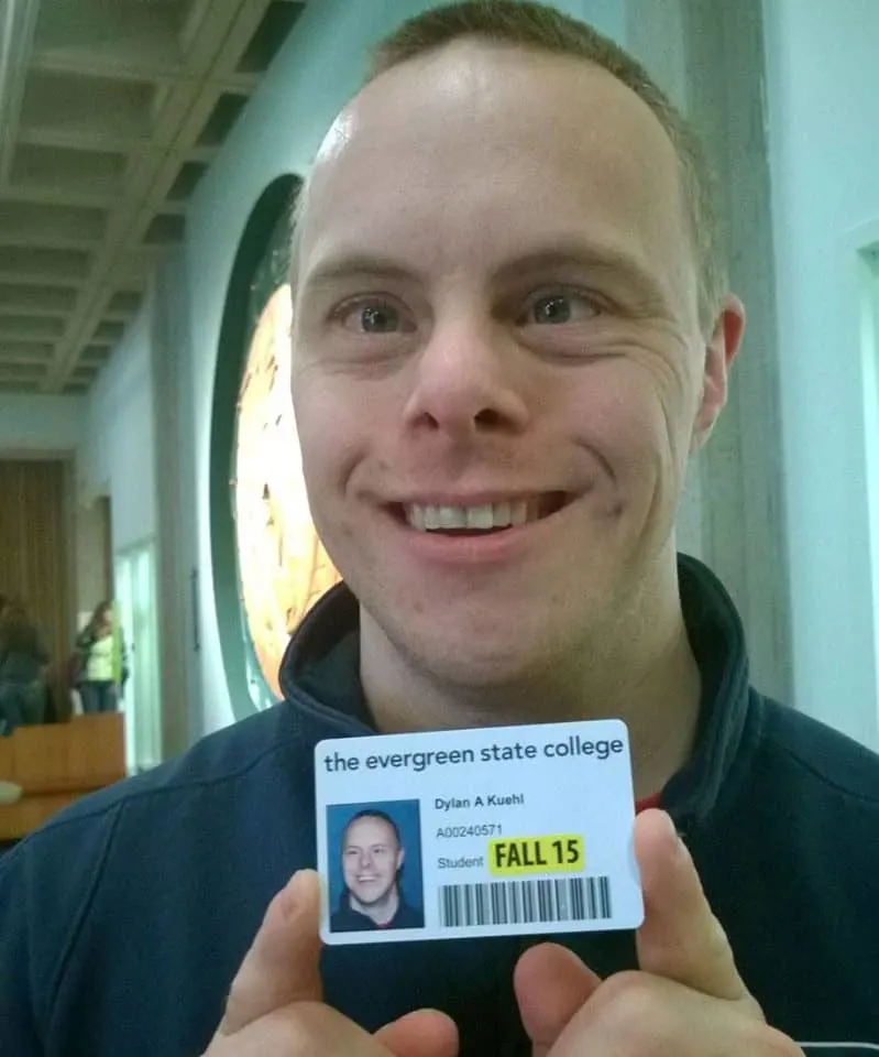Dylan Kuehl holding up his "The Evergreen State College" ID