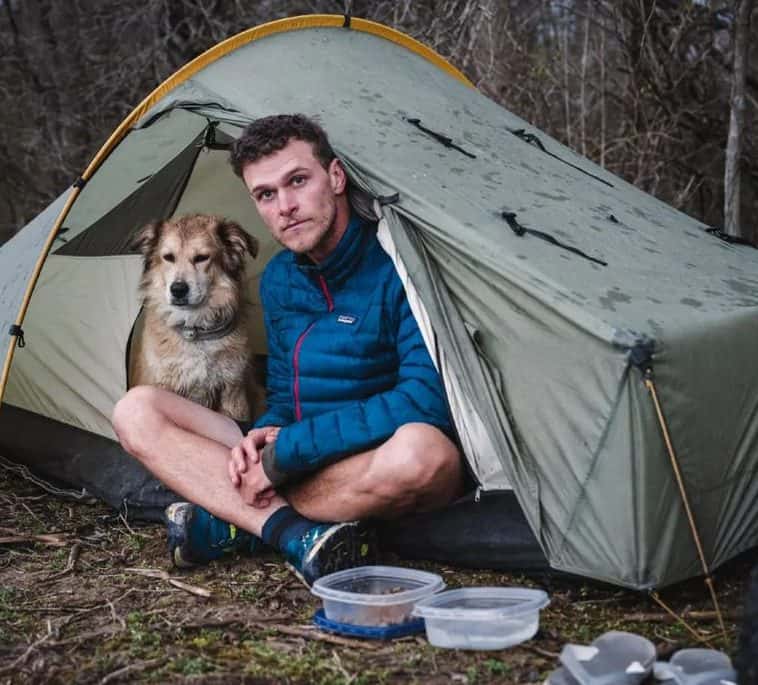 Tom Turcich and his dog Savannah inside a tent