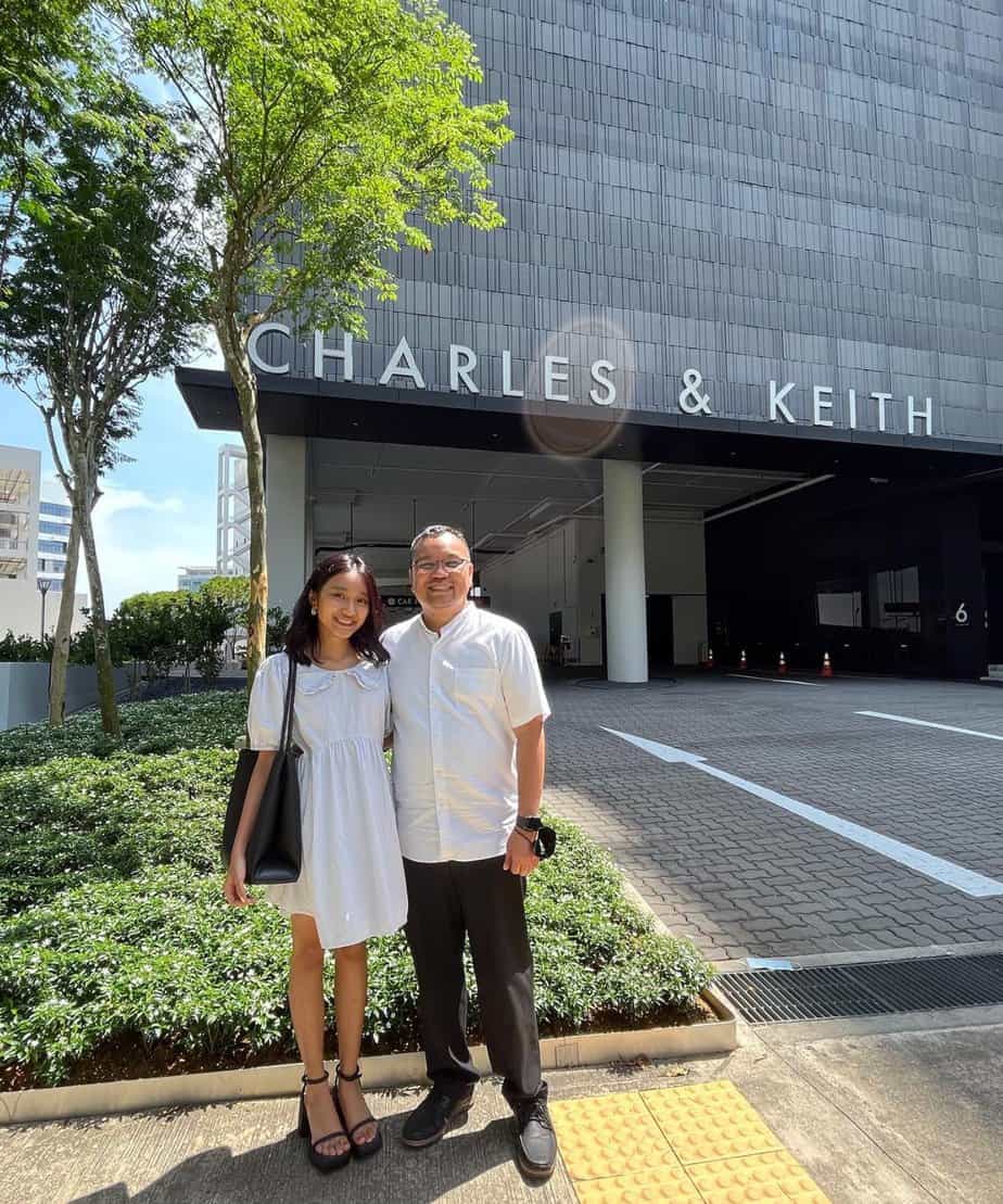 Zoe and her dad in front of luxury brand Charles & Keith's headquarters.