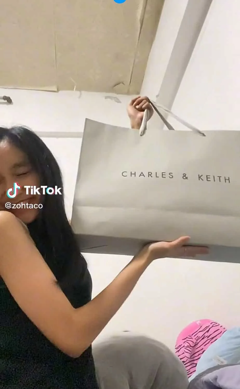 Zoe showing the packaging of her bag from a luxury brand.