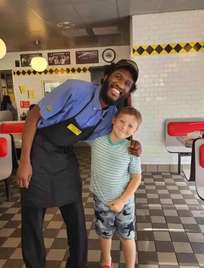 Kayzen and Devonte posing for a photo inside Waffle House.