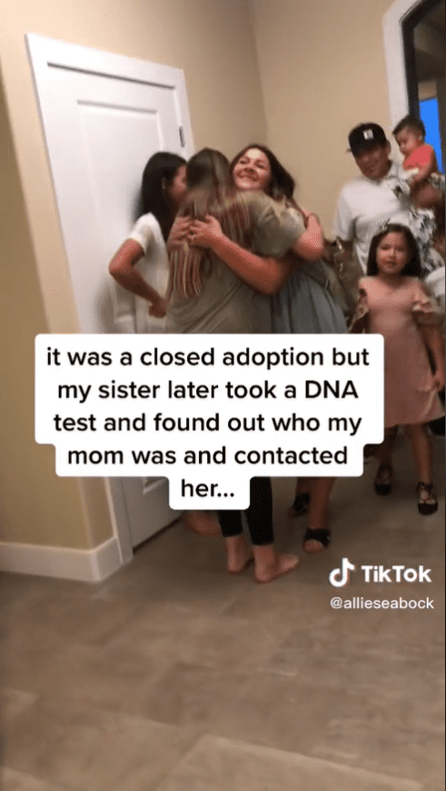 Siblings hug their mom's first born daughter, who was placed for adoption.