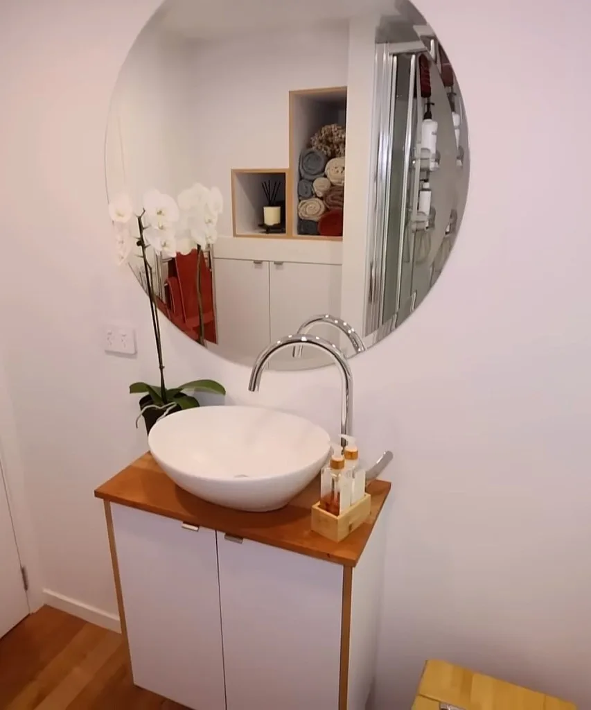 Bathroom's vanity with sink and large mirror.