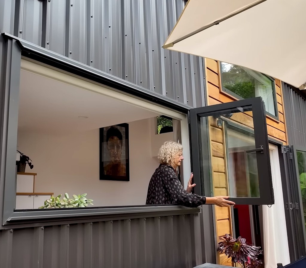 The forest tiny house has bifold windows that gives Christine an outdoor feels even if she is inside.