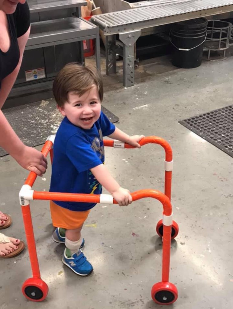 Logan smiling while trying the gait trainer.