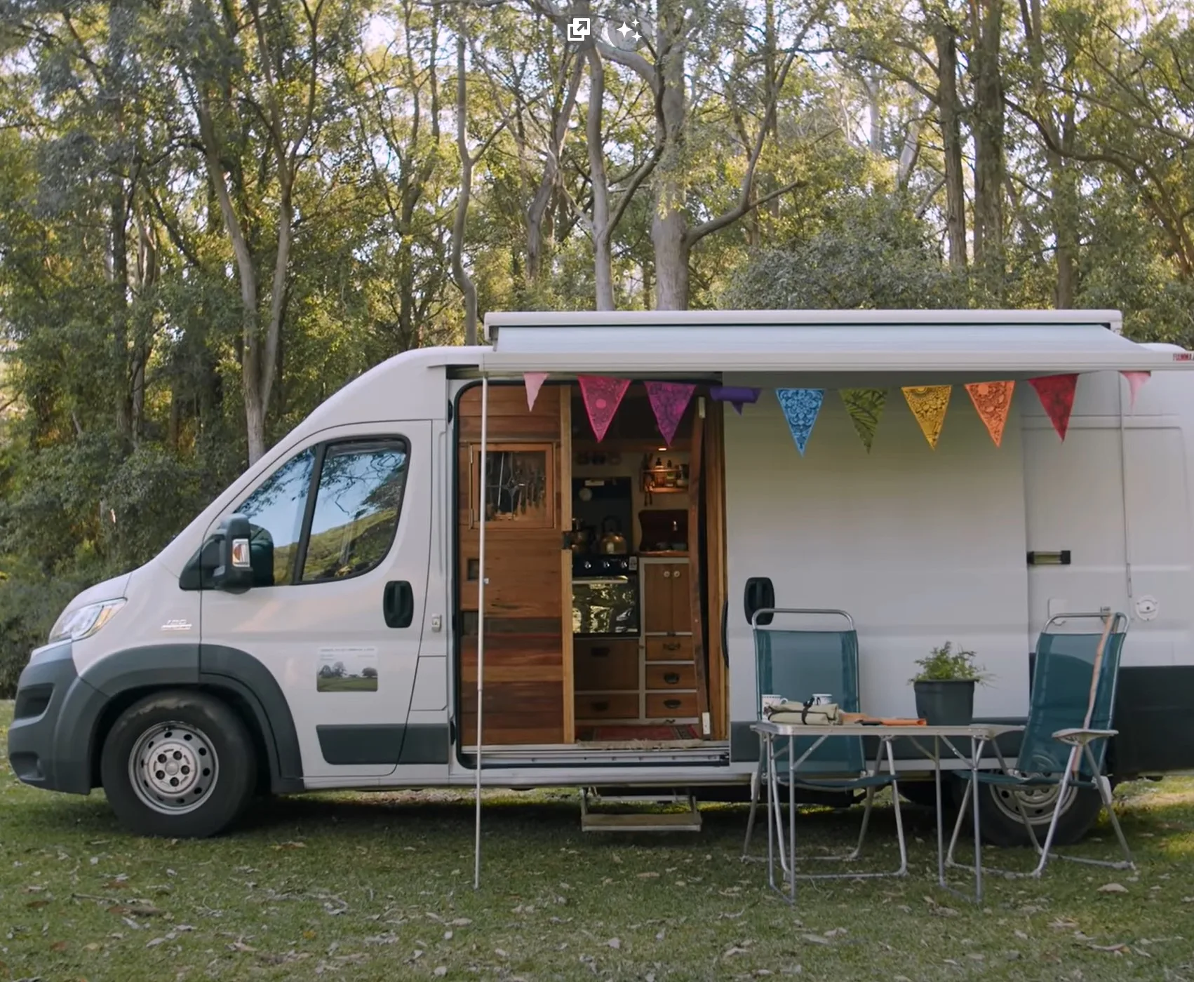 Side view of Claire's van showing its beautiful door and outdoor table and chairs.
