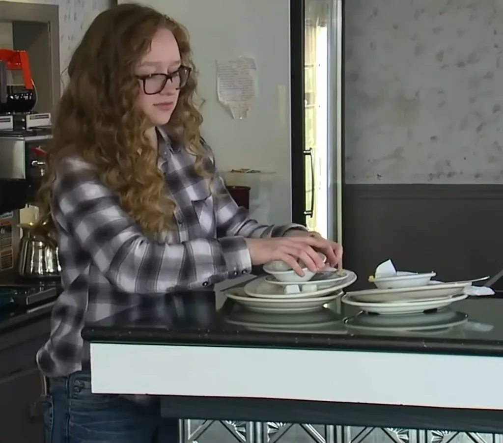 Samantha bussing out plates on the restaurant she bought using her college funds.