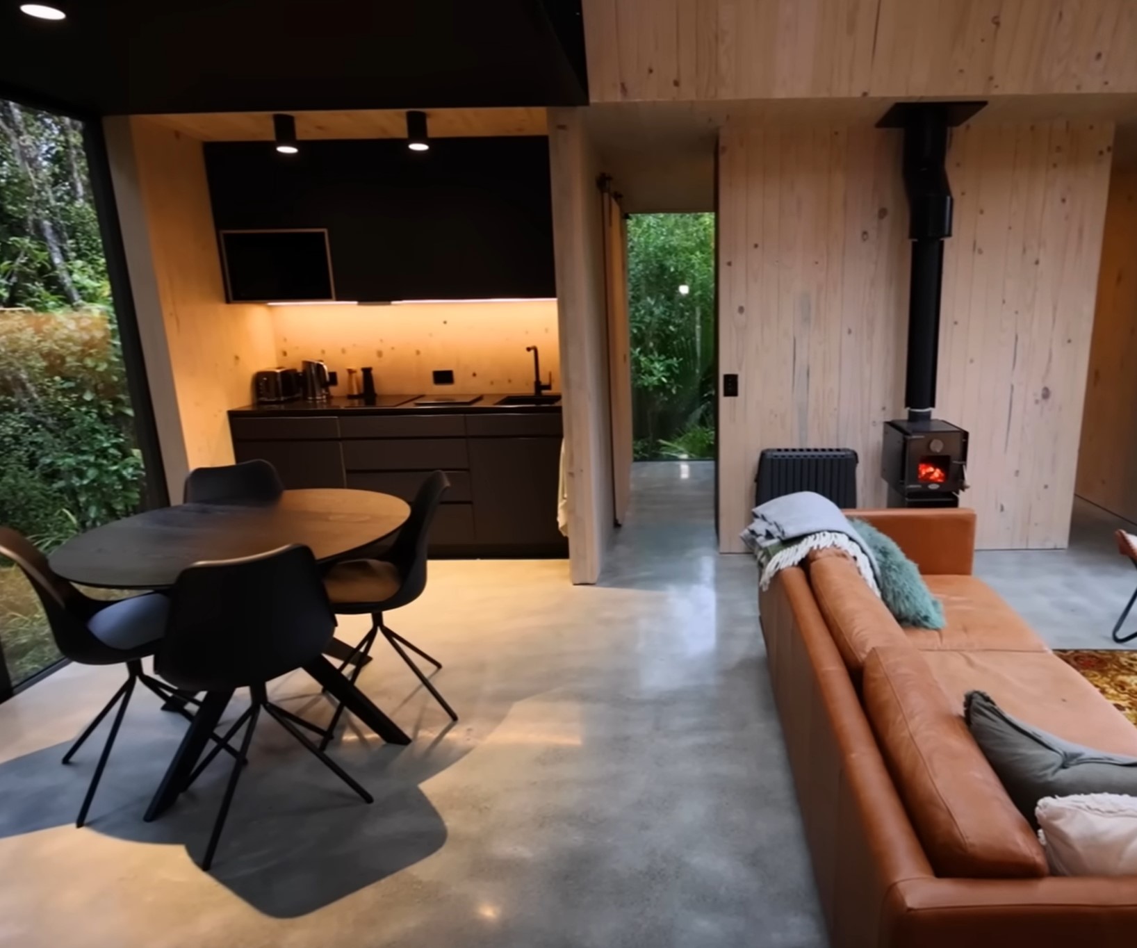 Inside the beautiful modenr cabin, showing the livingroom, kitchen and flooring.