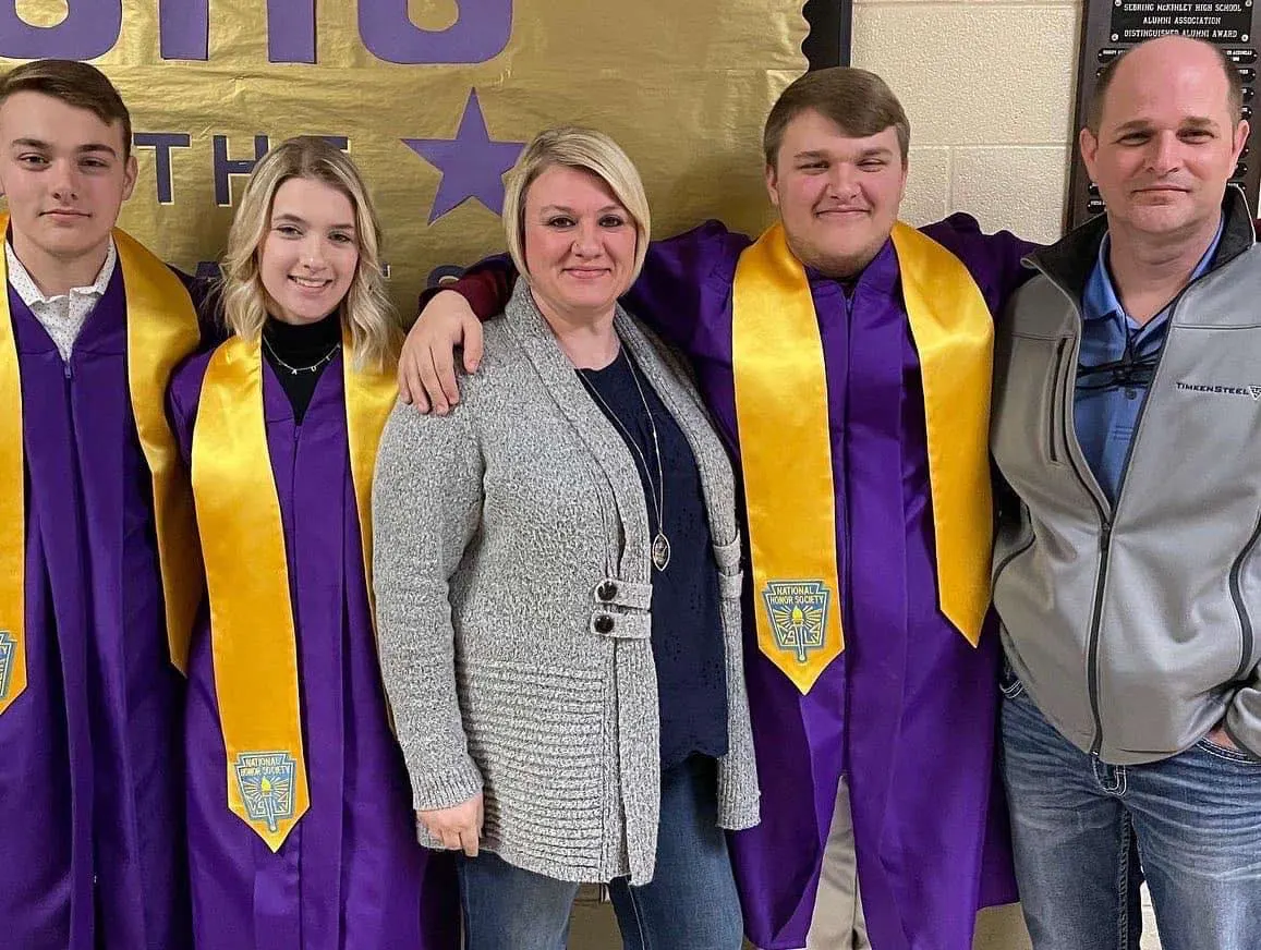 Triplets Caydin, Sadie, and Gage Barker pose with their parents at their high school graduation where they were honored as valedictorians and salutatorian.