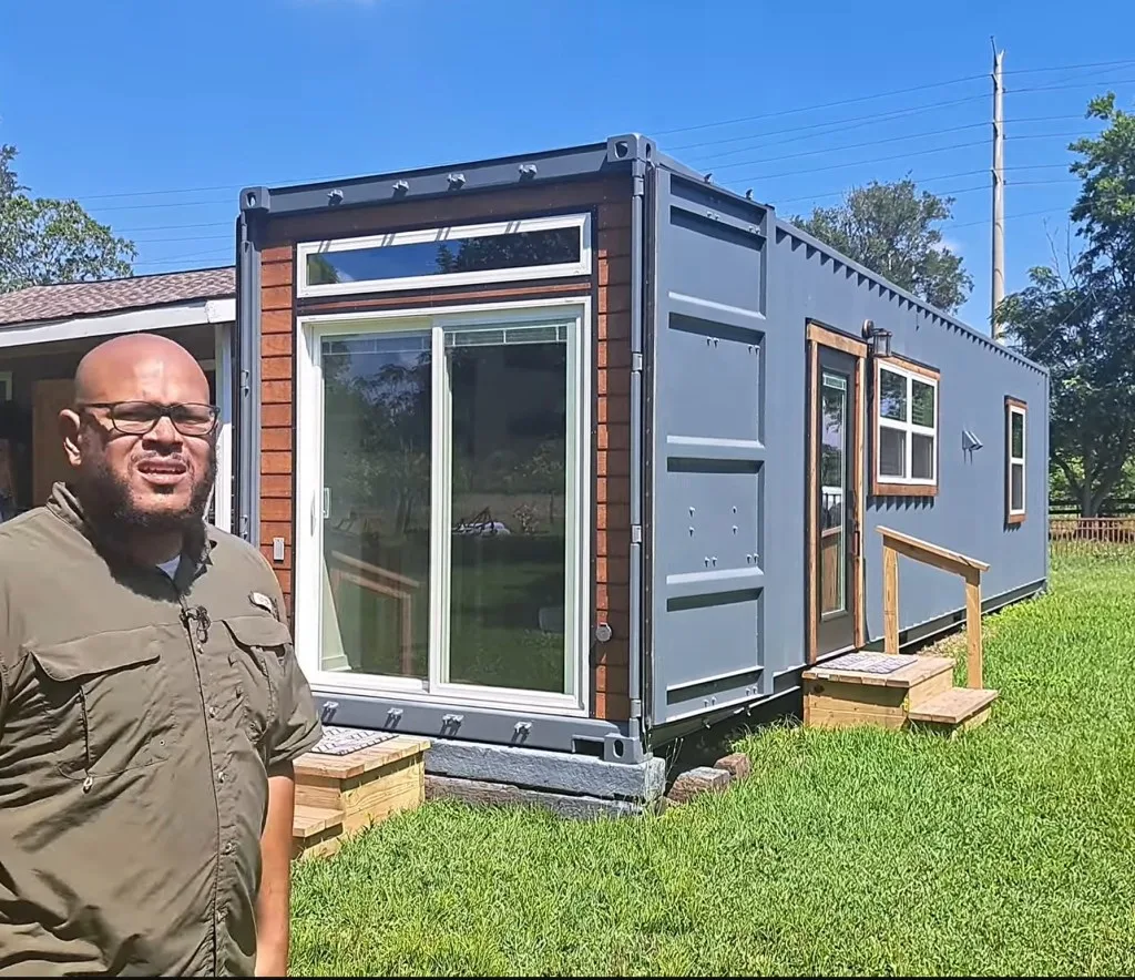 Micah showing the exterior of his container home he called 