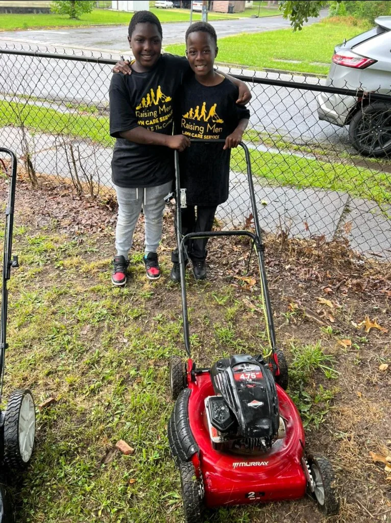 TJ and JT posing with their new lawnmower.