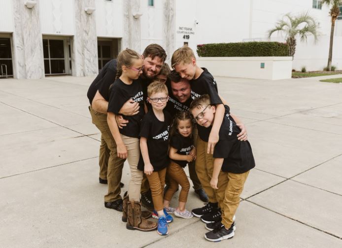 The Johnson family hug each other after the kids' successful adoption