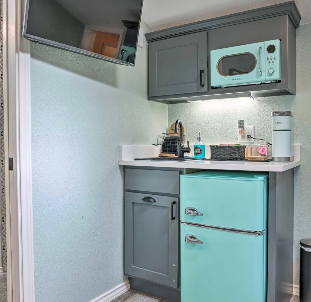 THe tiny house's kitchennette with mini fridge, microwave, and sink.