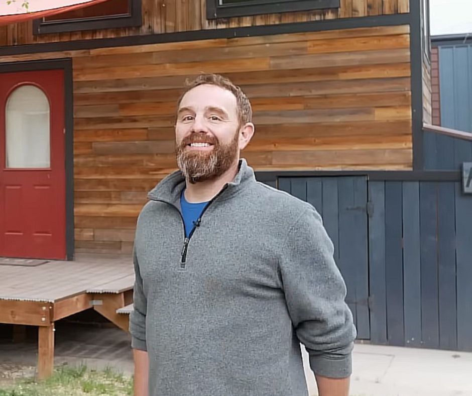 Kevin standing in front of his tiny home.