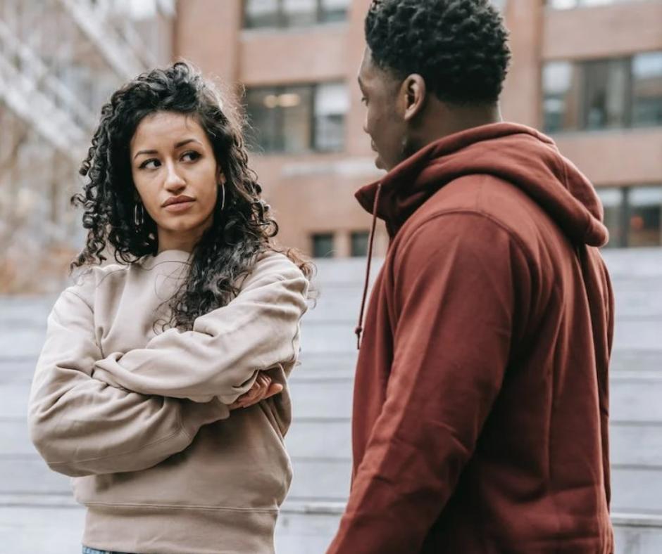 Woman looking at her boyfriend seemingly not happy with their relationship, starting to fall out of love.