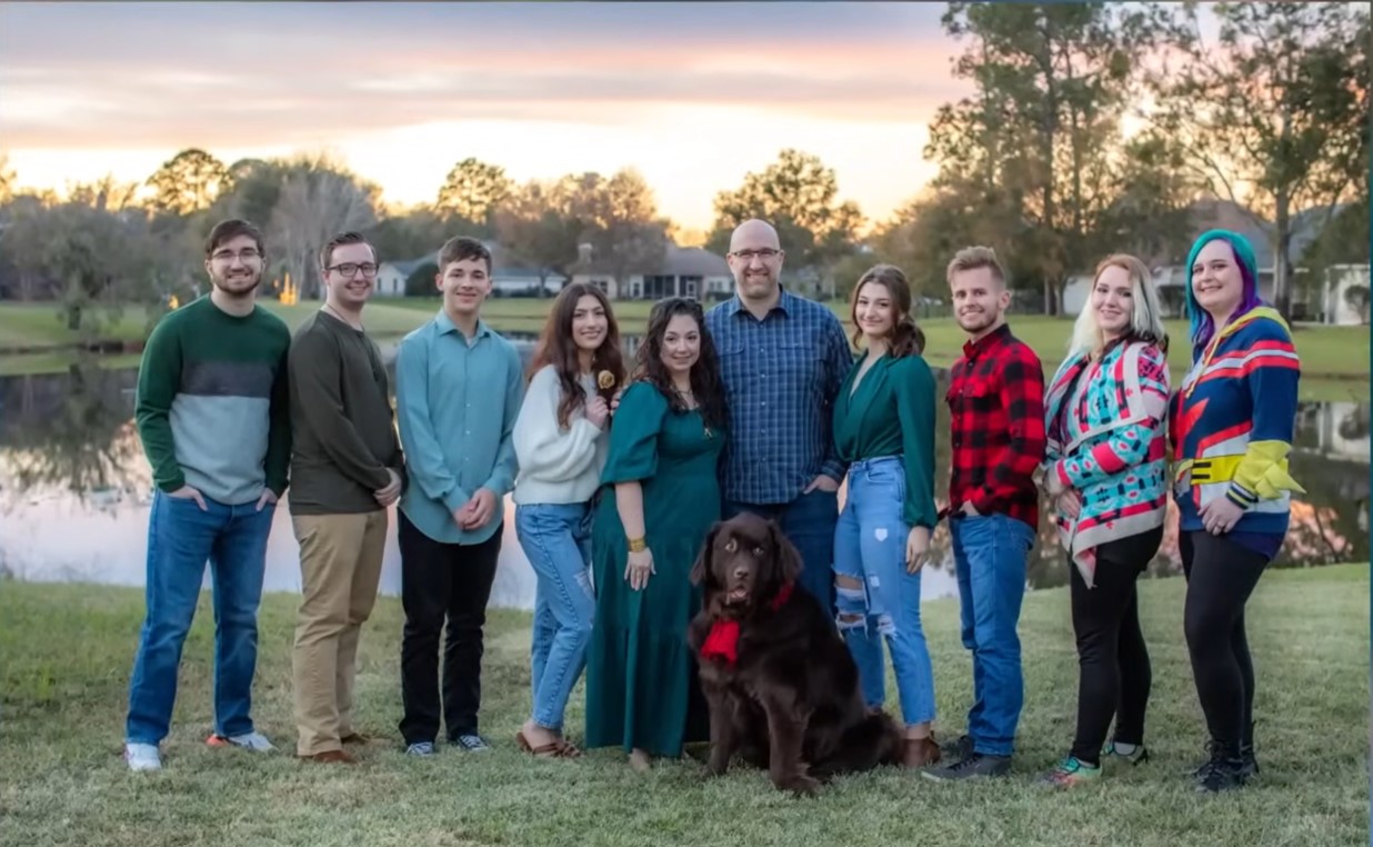 The Balassaitis family composed of Brad, Rene and their eight children pose for a picture with the family dog.