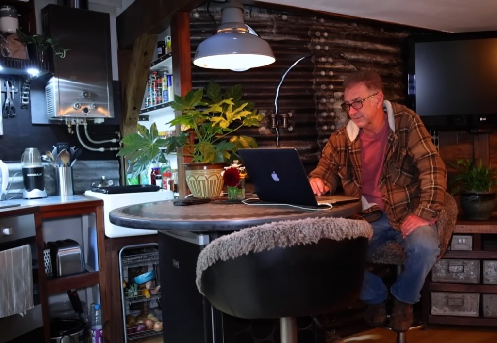 Bon on his computer working in their tiny home.