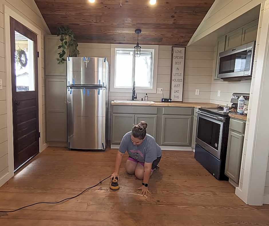 Katy, sanding the newly installed wooden floor.
