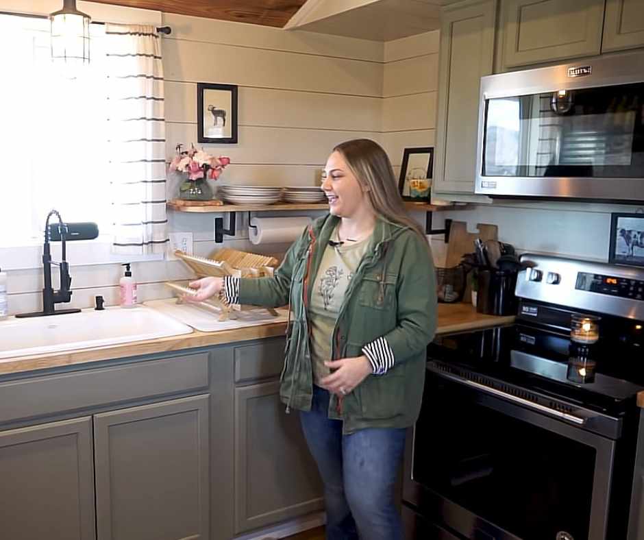 Katy showing the tiny home's fully equipped kitchen, showcasing a large stove, oven, large sink and spacious countertop.