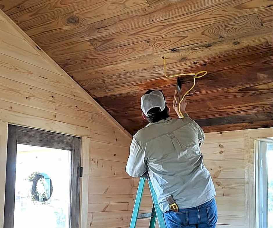Michael working on the electrical wires when they are turning an old shed into a tiny home.